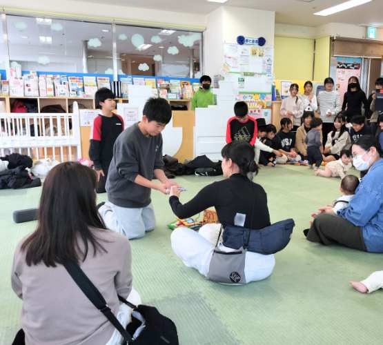 男の子がトランプのマジックをするのに観客のひろばの利用者にカードをひいてもらっている