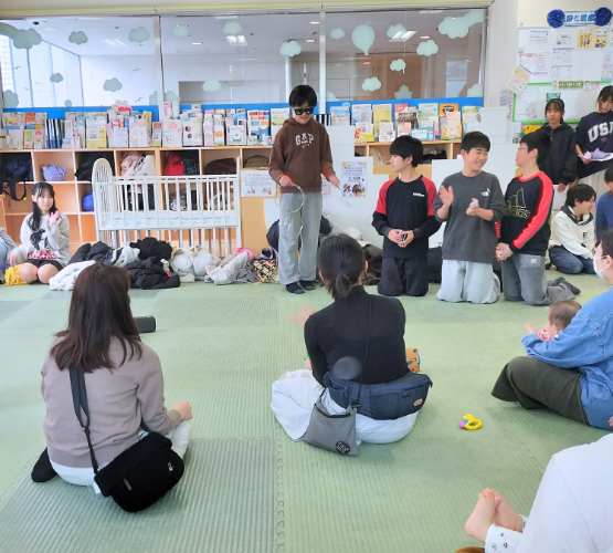 男の子がプロのマジシャンがしているようなサングラスをして大きなリングを数個使ってマジックをしている